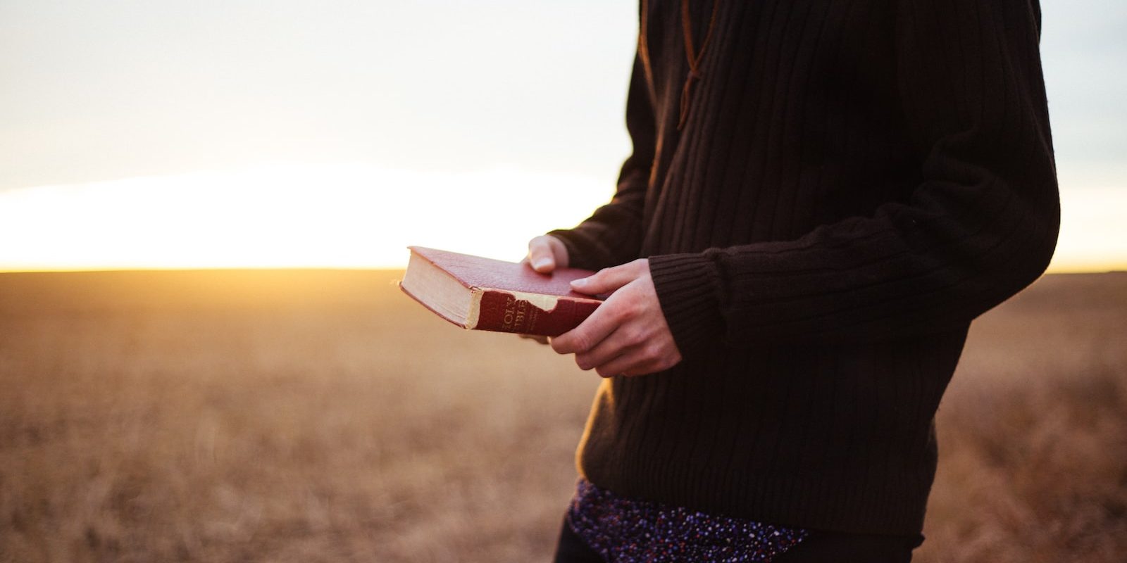 man holding book in the ricefield